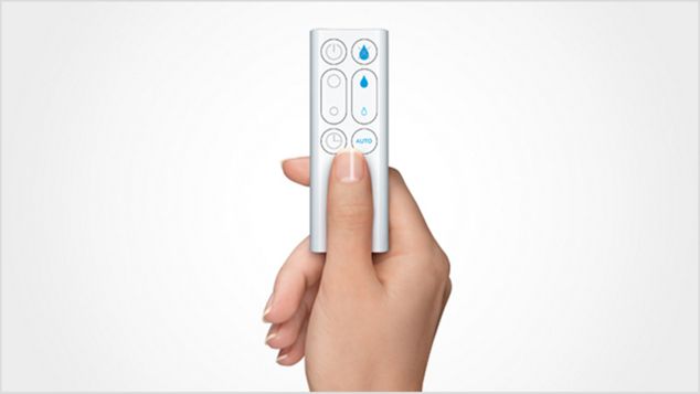 a hand touching a button on the remote control