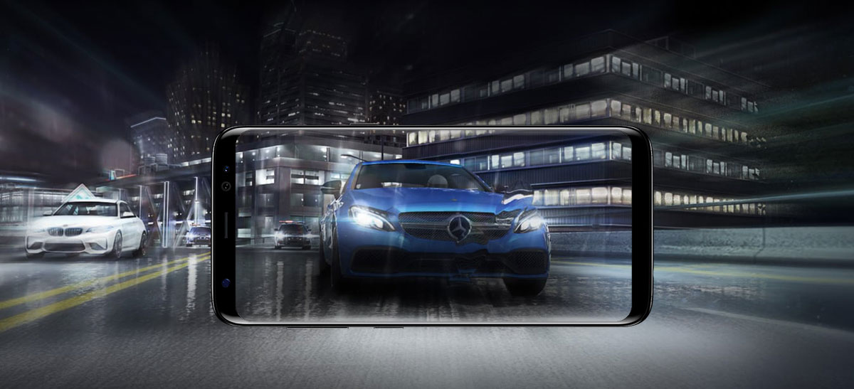 Samsung Galaxy S8 phone facing forward, lying horizontally blending in with the background of cars driving through a nighttime city street