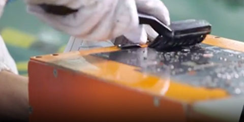 A gloved worker brushing the graphics card board
