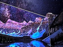 Paint splashes in front of a star-lit mountain range with tinges of purple, pink and black