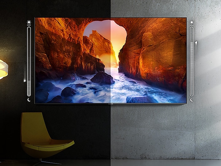 SAMSUNG Q80R TV Mounted on a Wall, Split in the Middle with a Brightness and Darkness Slider, It is darker on the left side of the image. The TV screenfill shows a river running through a canyon at sunset