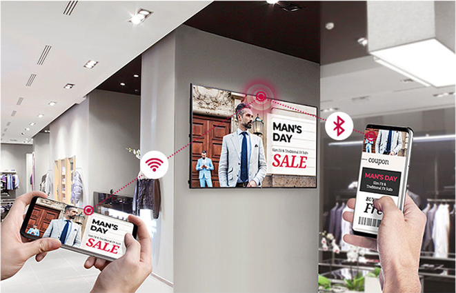Mounted LG Display in a men's clothing store with two different sets of hands connecting to it via WiFi and Bluetooth respectively