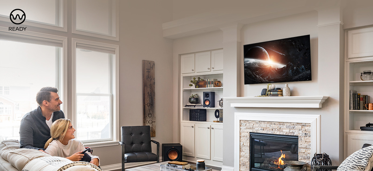A woman and a man are watcing TV together and the icon of WiSA ready is listed at the top left corner.