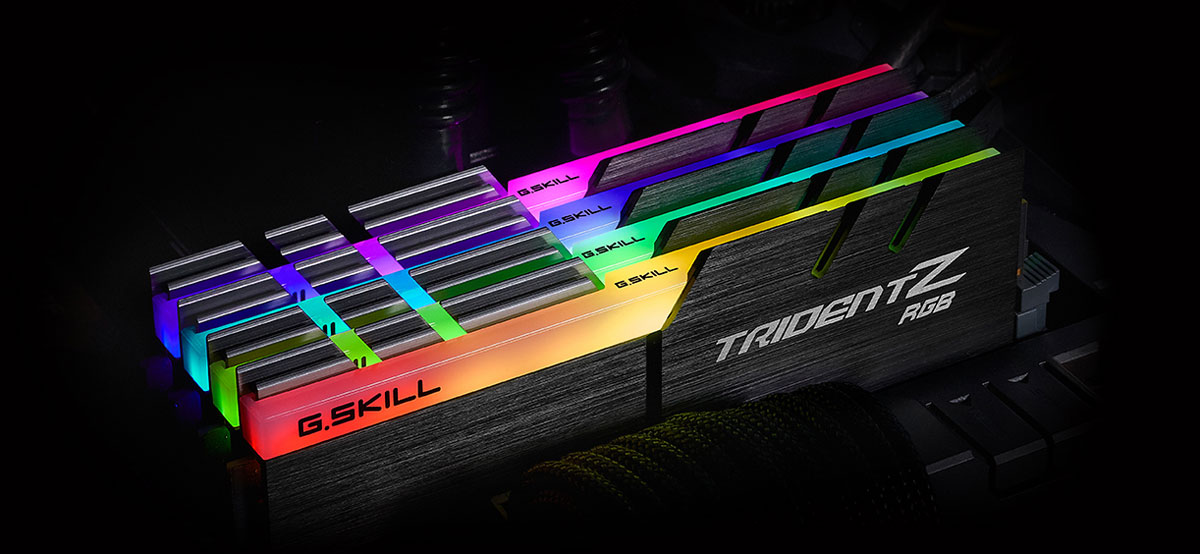 Top front view of four Trident Z modules on a motherboard, each glowing different colors on the RGB strip