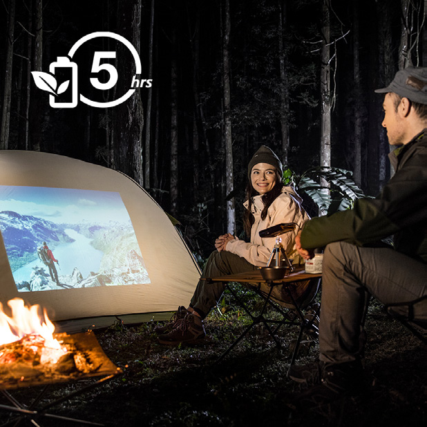 A man and woman next to their tent and campfire at night