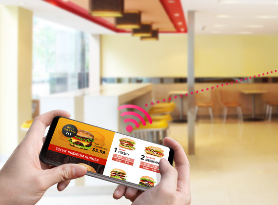 A smartphone with a burger restaurant ad on screen