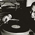 An Older Man Placing a Needle on a Record