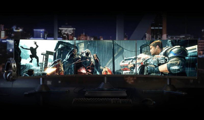 three-monitor setup showing a game scene