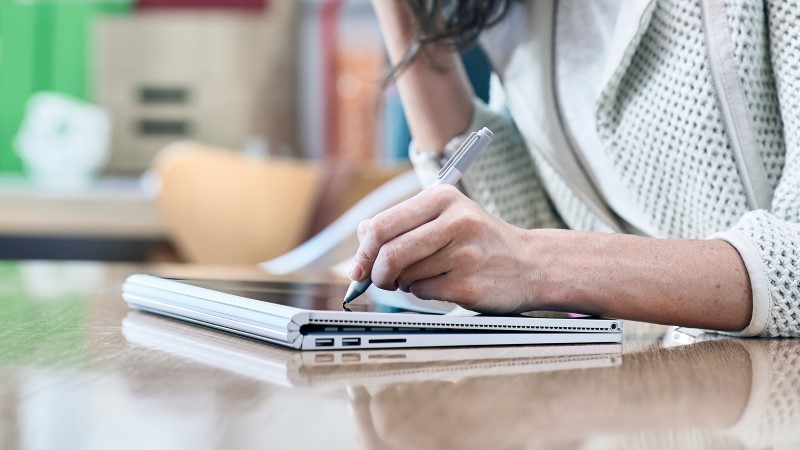 a woman taking notes with Surface Pen on Surface Book