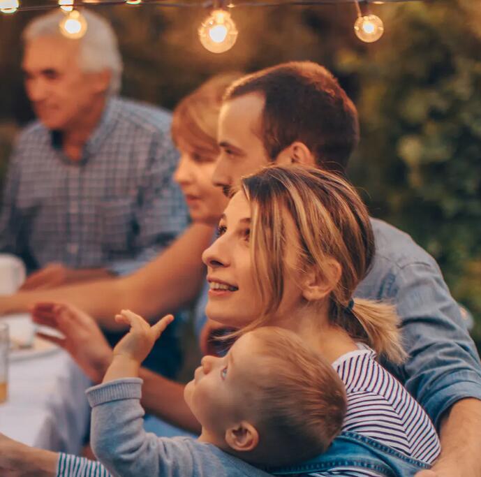 A woman is smiling at the outdoor lights which controlled by Kasa smart plug.