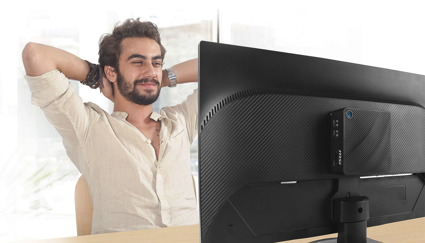 A man is smiling and watching the monitor. The Cubi N is mounting on the back of monitor.