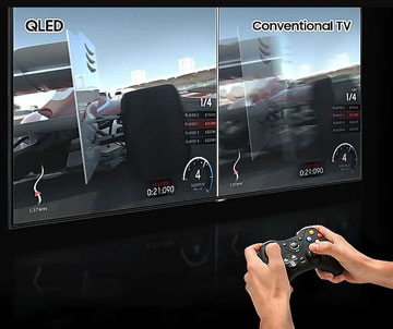 Two hands using a game controller in front of a Samsung Q70R with a racing game on screen that's split to show the difference between QLED and conventional TV display technology