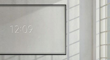 A mounted Samsung Q70R display showing the time