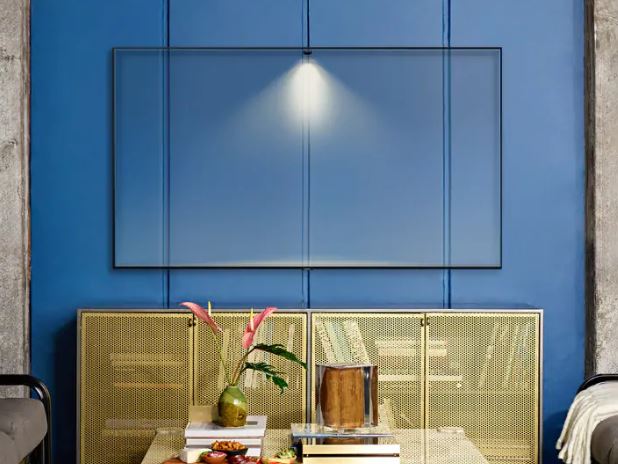 Mounted Samsung Q70R display blending in with the three-paneled blue wall it is on