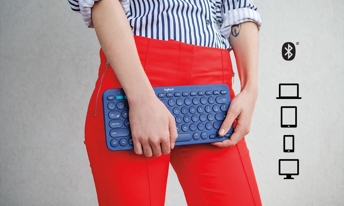 a woman holding a blue Logitech K380 keyboard