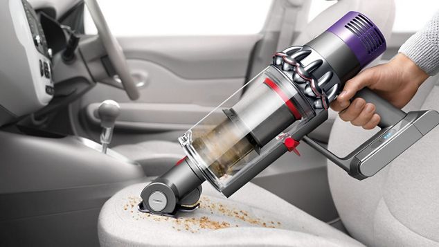 handheld vacuum cleaner cleaning debris on car seat