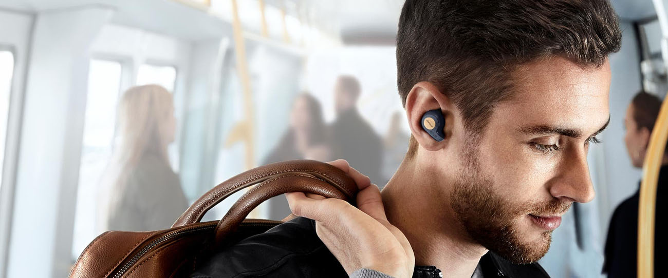 A young man on his morning public-transport commute listening to his Jabra earbuds