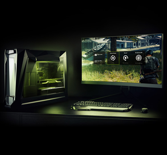 A PC, monitor keyboard + mouse setup showing lighting from the desktop PC and a game screenshot on the monitor