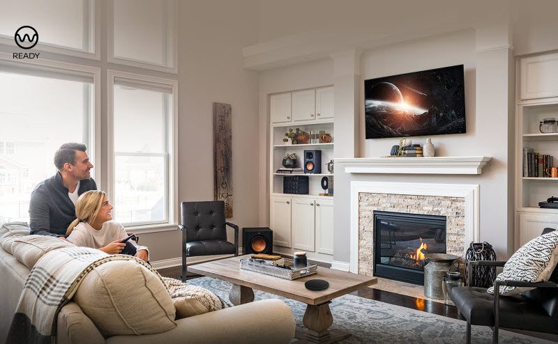 a man and a woman are watching a show in their living room