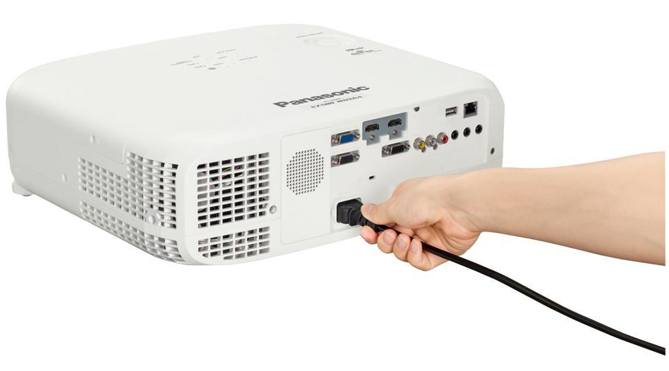 A hand plugging in a power cable to the back of the Panasonic PT-VZ580U Lumens LCD Projector 