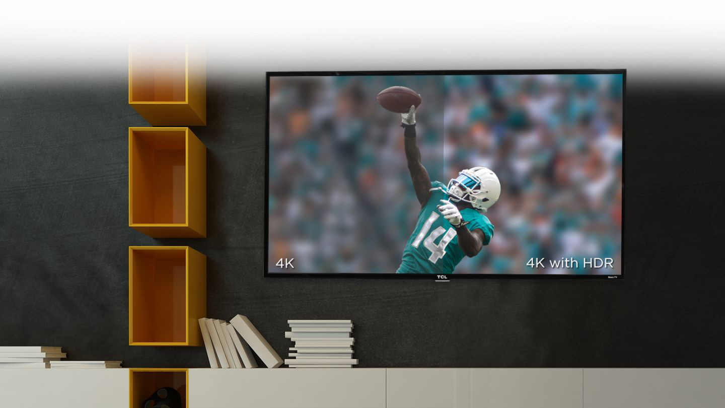 TCL Display Mounted a Wall Next To Mounted Floating Cabinet. The Display Shows a Football Player Making a One-Handed Catch in front of a crowd