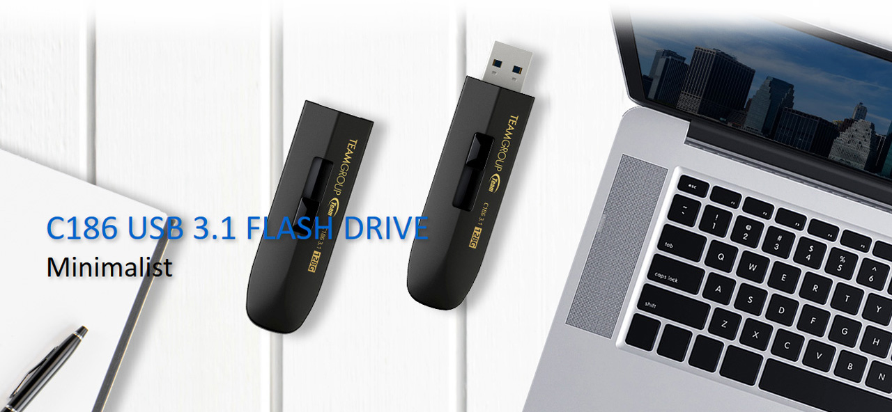 Team Group C186 Flash Drives Next to an Open Macbook Laptop and a pen with notebook. One flash drive is closed and the other is open. There is text that reads: C186 USB 3.1 FLASH DRIVE - Minimalist