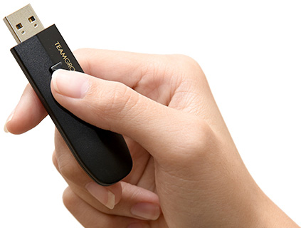 A Hand Pushing the Retractable Function of the Team Group USB Drive