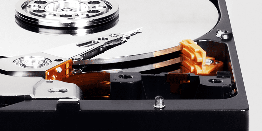  Vista parcial de la estructura interna de un disco duro, que muestra discos, brazo y cabezal de grabación, bobina y más  