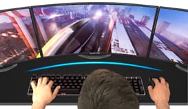 A Man with Keyboard, Mouse and Three Curved Monitors Showing Gameplay