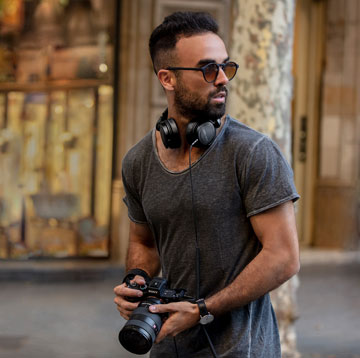 A Male Photographer with Beyerdynamic headphones around his necl