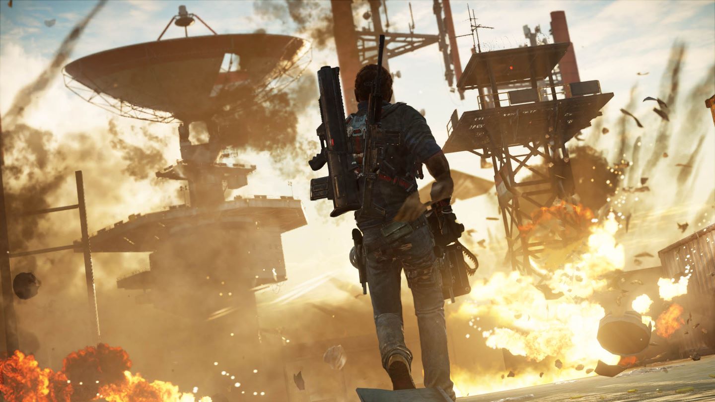Just Cause 3 Screenshot Showing the Main Character with a Rail Gun Approaching an Exploding Ground Satellite Area