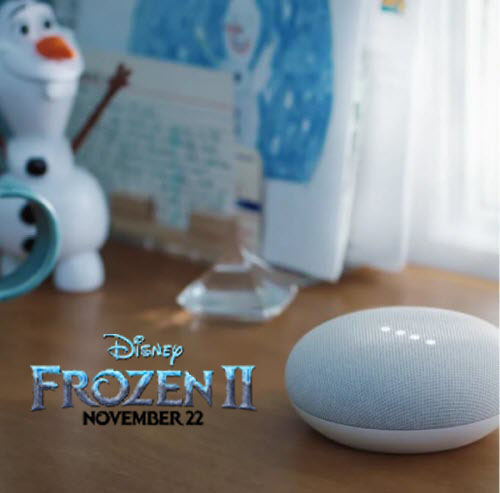 Google Nest Mini placed on a wooden desk with a Frozen 2 logo