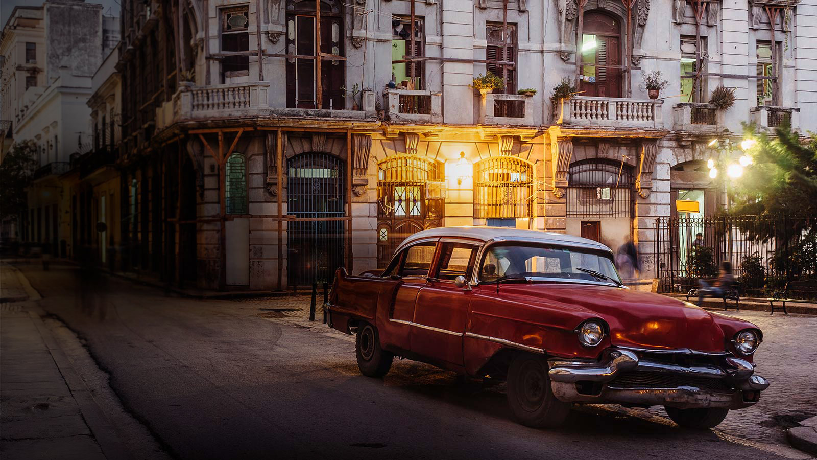 A classic car next to an old European residential city area
