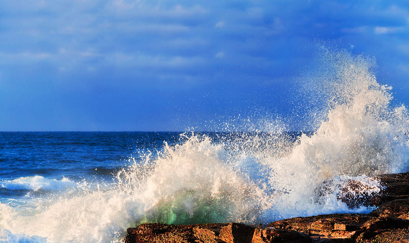Waves from the ocean crashing onto rocks