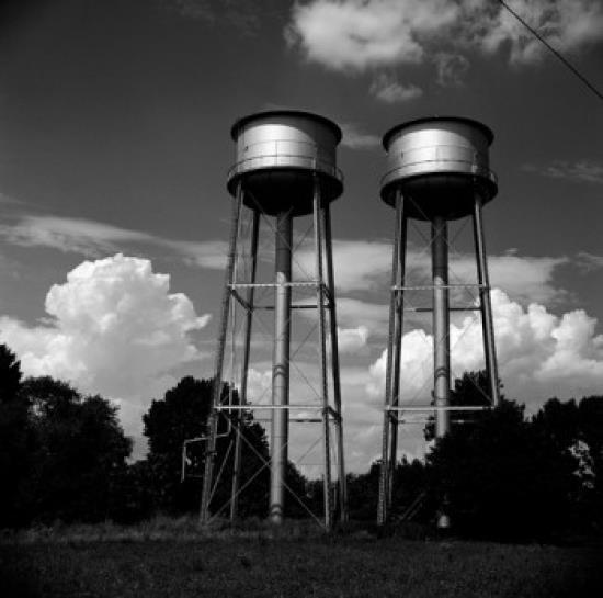 Water tanks against cloudy sky Poster Print (18 x 24)